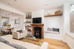 ein Wohnzimmer mit einem Kamin und einem TV in der Unterkunft Beautiful 3 bed Cottage Chorleywood. in Chorleywood