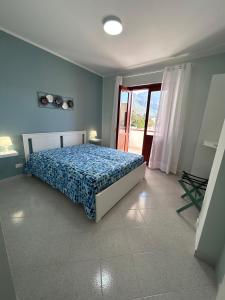 um quarto com uma cama com um edredão azul em Yucca Apartment em San Vito lo Capo