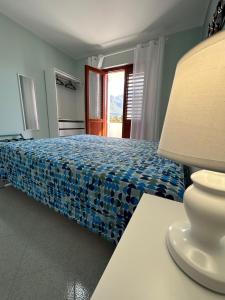 um quarto com uma cama e uma mesa com um candeeiro em Yucca Apartment em San Vito lo Capo