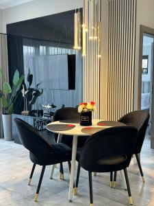a dining room with a table and black chairs at Apartamenty Blue Baltic Chłopy nad morzem in Chłopy
