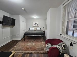 sala de estar con cama y silla en Cozy King Bed Stay at the Historic Inman - 201, en Champaign