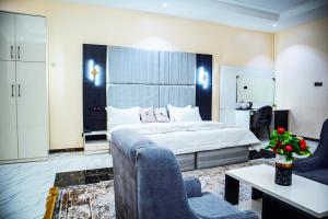 um quarto de hotel com uma cama e um sofá em Pula Pula Luxury Hotel and Suites em Karewa