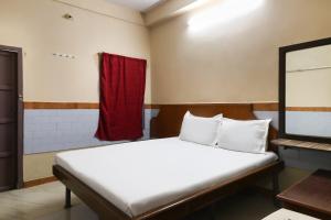a bedroom with a bed and a red curtain at OYO Jayanthi Mansion in Chennai