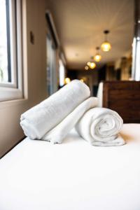 três toalhas empilhadas num balcão na casa de banho em The Hideaways em Exeter