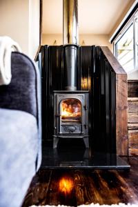 a stove in a living room with a fireplace at The Hideaways in Exeter