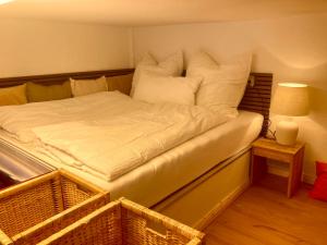 a bed with white sheets and pillows in a room at Mini-Appartements am Burgberg in Bad Harzburg