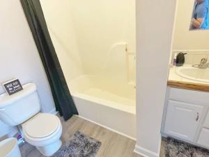 uma casa de banho com um WC, um lavatório e uma banheira em Housepitality - The Bliss Lodge - Large House em Columbus