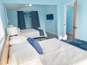 um quarto com 2 camas e paredes azuis em Housepitality - The Bliss Lodge - Large House em Columbus