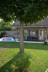 un árbol en un patio con piscina en Maison de 5 chambres avec piscine privee sauna et terrasse a Bellegarde Poussieu, en Bellegarde-Poussieu