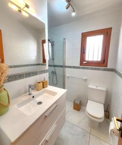 a bathroom with a toilet and a sink and a mirror at Ocean Wave in Acantilado de los Gigantes