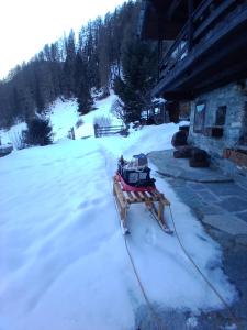 a snow sled is parked outside of a house at Chalet quota 1800 in Saint Jacques