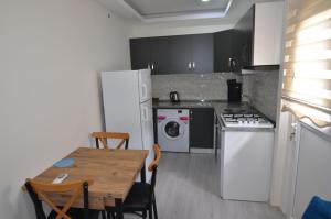 a kitchen with a table and a white refrigerator at Mykonut Apart Hotel in Fethiye