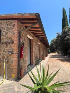 a brick building with a red fire hydrant on it at Agriturismo La Vergheria in Macchiascandona