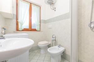 La Casetta di Procchio by HelloElba في بروكيو: حمام أبيض مع حوض ومرحاض