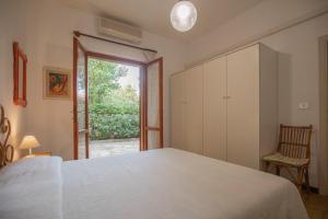 a bedroom with a large white bed and a window at La Casetta di Procchio by HelloElba in Procchio