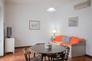 La Casetta di Procchio by HelloElba في بروكيو: غرفة معيشة مع طاولة وأريكة