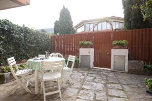 a patio with a table and chairs and a fence at La Casetta di Procchio by HelloElba in Procchio