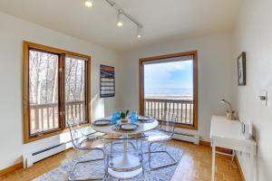 comedor con mesa, sillas y ventanas en Lake Michigan Home with Private Beach and Deck!, en Menominee