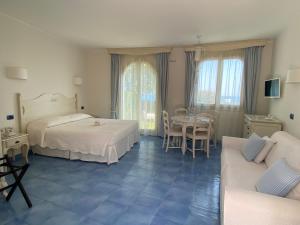 una camera con due letti, un tavolo e un divano di Baia Delphis Resort a Vasto