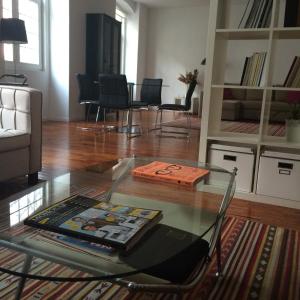 リスボンにあるBelong Staying and Feeling - Casa da Séのリビングルーム(ガラスのテーブル、椅子付)