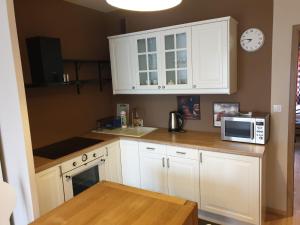 a kitchen with white cabinets and a microwave at APARTAMENT KLONOWA 3 POKOJE in Kielce