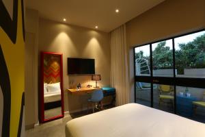 
a hotel room with a bed and a television at Cucu Hotel By 7Minds in Tel Aviv
