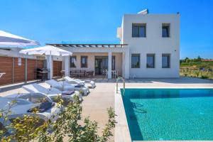 a villa with a swimming pool and a house at Villa Panaxia Votsalo in Theologos