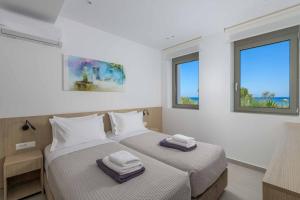 two beds in a room with two windows at Villa Panaxia Votsalo in Theologos +18 photos