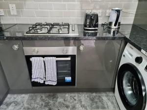 a kitchen with a stove and a washing machine at Beautiful 2-Bed House in London in London