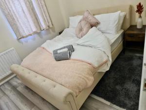 Una cama pequeña con manta y almohadas. en Beautiful 2-Bed House in London, en Londres