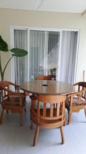 a dining room with a wooden table and chairs at Rumah Menik in Uluwatu