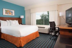 ein Hotelzimmer mit einem Bett, einem Schreibtisch und einem TV in der Unterkunft Fairfield Inn Charlotte Gastonia in Gastonia