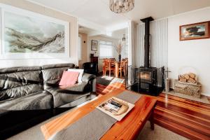 a living room with a couch and a wood stove at Alpine House Tongariro - Turangi Holiday Home in Turangi