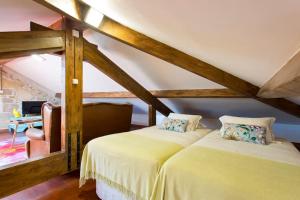 ヴィラ・ノヴァ・デ・ガイアにあるHC Villa Douroのベッド2台 木製の梁のある部屋