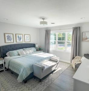 Un dormitorio con una cama azul y una ventana en Track View 4 br Townhome Next to Road America, en Plymouth