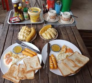 une table avec des assiettes de petit-déjeuner dessus dans l'établissement sofee homestay(Bulone Island)langu Satun Thailand, à Ko Bulon Le