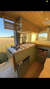 uma cozinha com um lavatório e um fogão num trailer em Furgoneta camperizada em Playa de las Americas