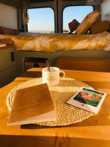 Furgoneta camperizada في بلايا ذي لاس أميريكاس: طاولة مع كوب من القهوة وكتاب