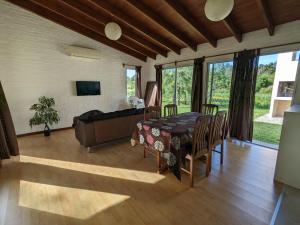 a dining room with a table and a couch at Portal Del Campo in Piriápolis +15 photos
