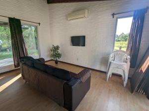 a living room with a couch and a white chair at Portal Del Campo in Piriápolis