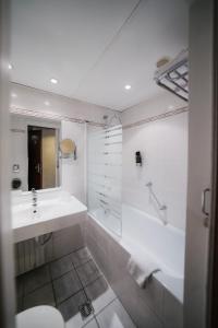 a bathroom with a sink and a tub and a toilet at Savoy Hotel in Frankfurt