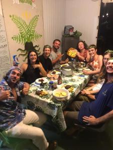 un grupo de personas sentadas alrededor de una mesa comiendo en ALAROOTS HUAHINE en Haapu