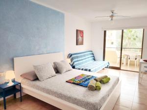 - une chambre avec un lit et un canapé bleu dans l'établissement Castel Harbour Tenerife, à Los Cristianos