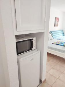 eine Mikrowelle auf einem Kühlschrank im Zimmer in der Unterkunft Castel Harbour Tenerife in Los Cristianos