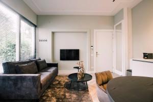 ein Wohnzimmer mit einem Sofa und einem Tisch in der Unterkunft Luxurious Apartment With Garden Hendrik's in Tilburg