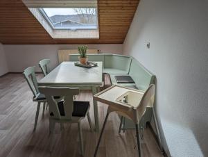 a dining room with a table and chairs and a window at Ferienwohnung Pusteblume in Marktbergel
