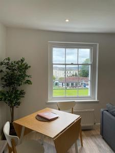 a living room with a table and a window at Apartment 4 St Georges in Cheltenham
