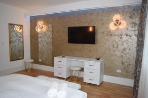 1 dormitorio con 1 cama y TV en la pared en Rokebea Luxury en Brasov