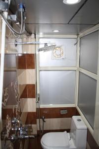 a bathroom with a toilet and a shower with a clock at Raghunath Palace Home Stay in Varanasi