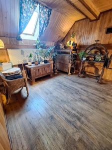 a living room with wooden floors and a large window at Karkonoska Drewniana Chata in Kamienna Góra